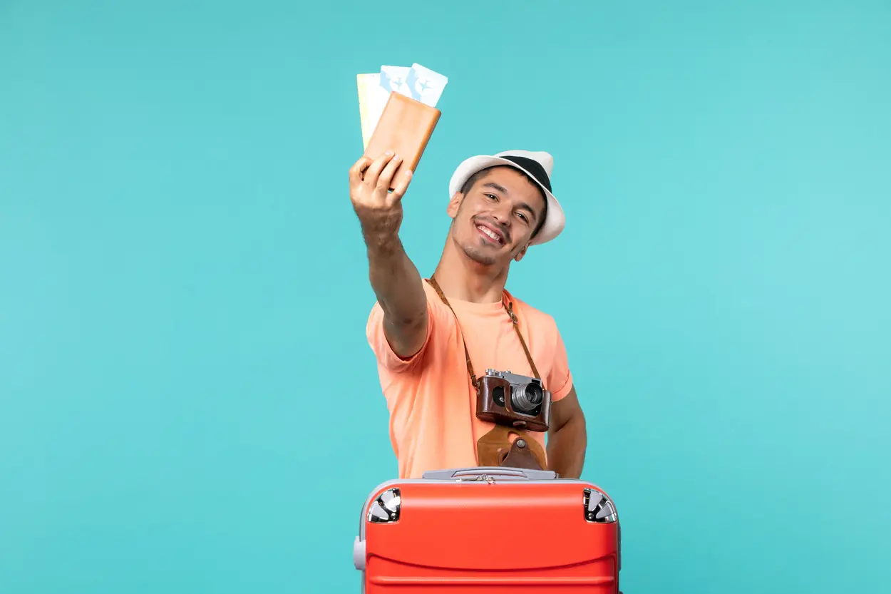 Homem com mala de viagem segurando passagens